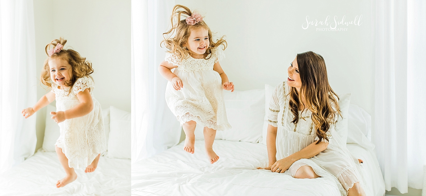 A little girl jumps on the bed  | Sarah Sidwell Photography | Newborn Love