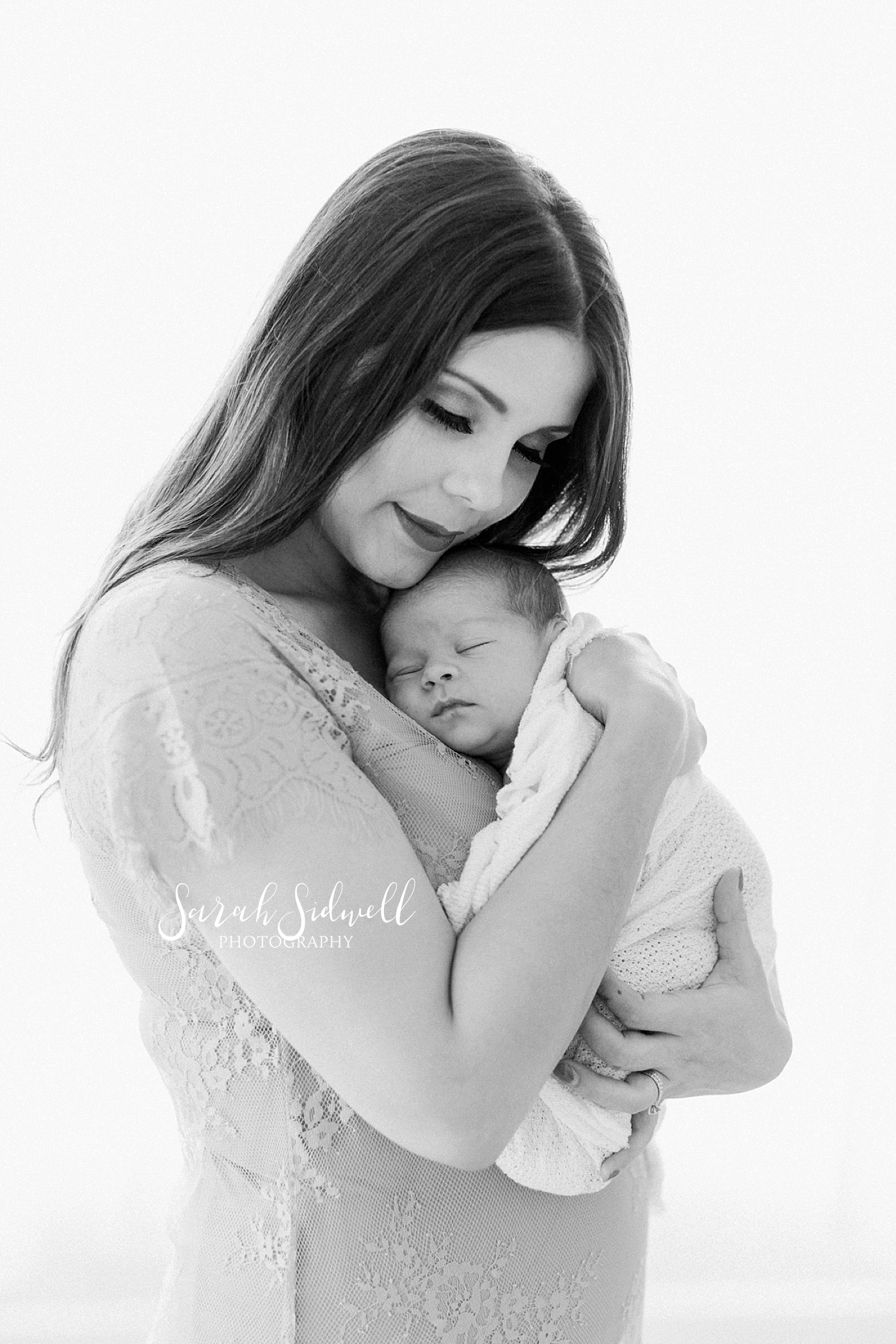 A mother holds her new baby close  | Sarah Sidwell Photography | Newborn Love