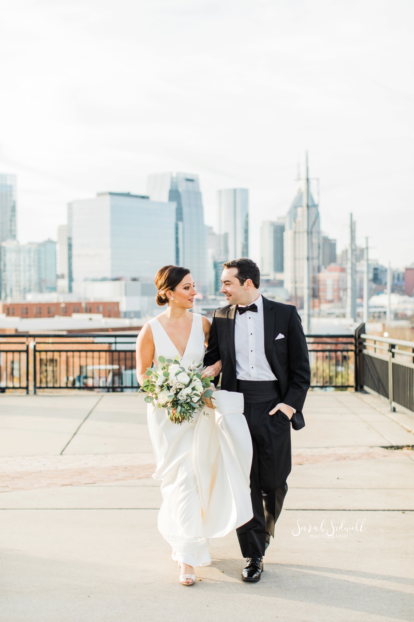 A bride and groom walk together | Sarah Sidwell Photography | The Bell Tower