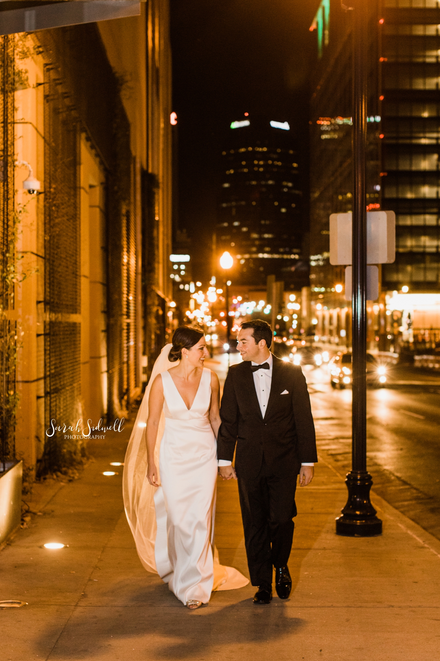 A bride and groom take a walk on a city street | Sarah Sidwell Photography | The Bell Tower