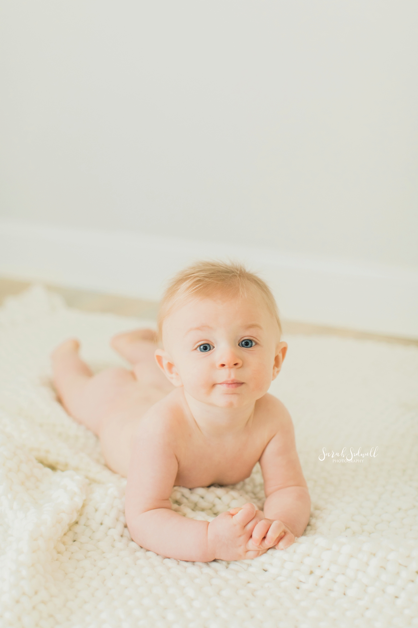 Baby Oliver lays on the floor for his half birthday photos. 