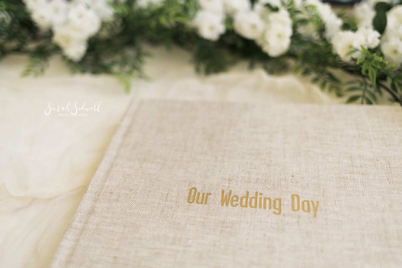 A wedding album is displayed with gold etching on the front. 