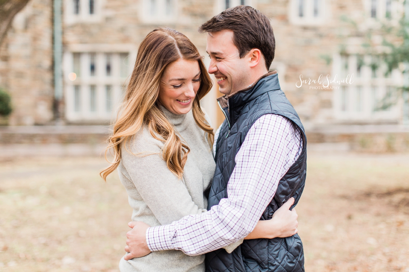 A couple laugh together, captured by a Nashville Engagement Photographer