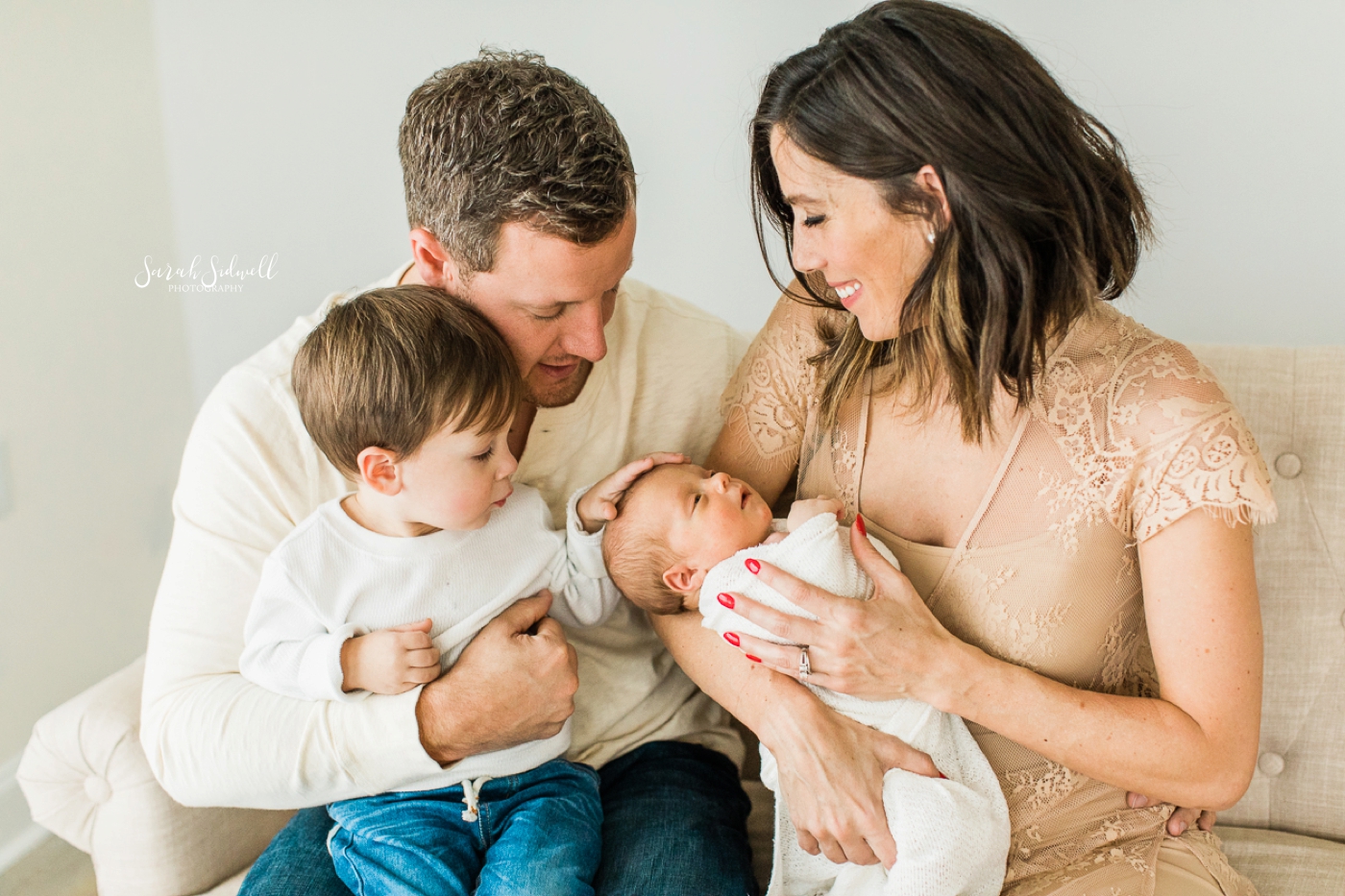 A family shares a sweet moment, captured by a Nashville Newborn Photographer. 