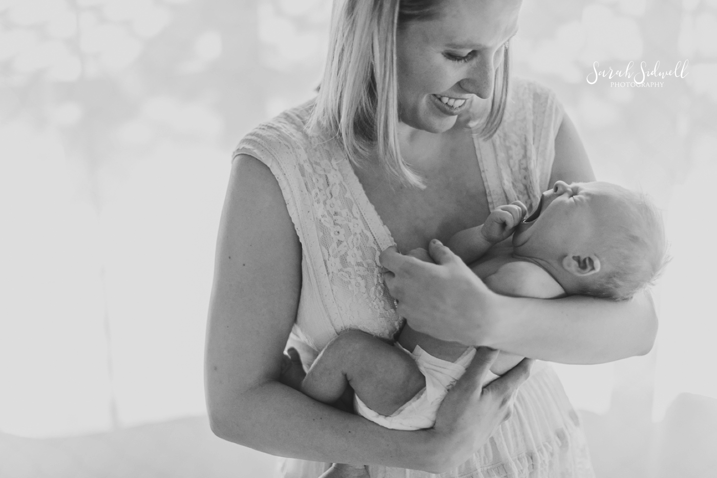A mother holds her baby for a photo taken by a newborn photographer Nashville. 