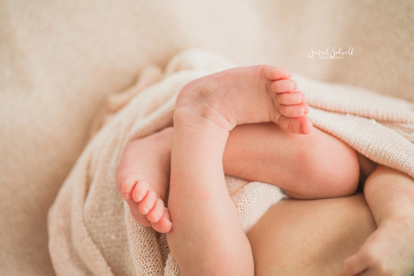 A baby's feet are crossed like a pretzel. 