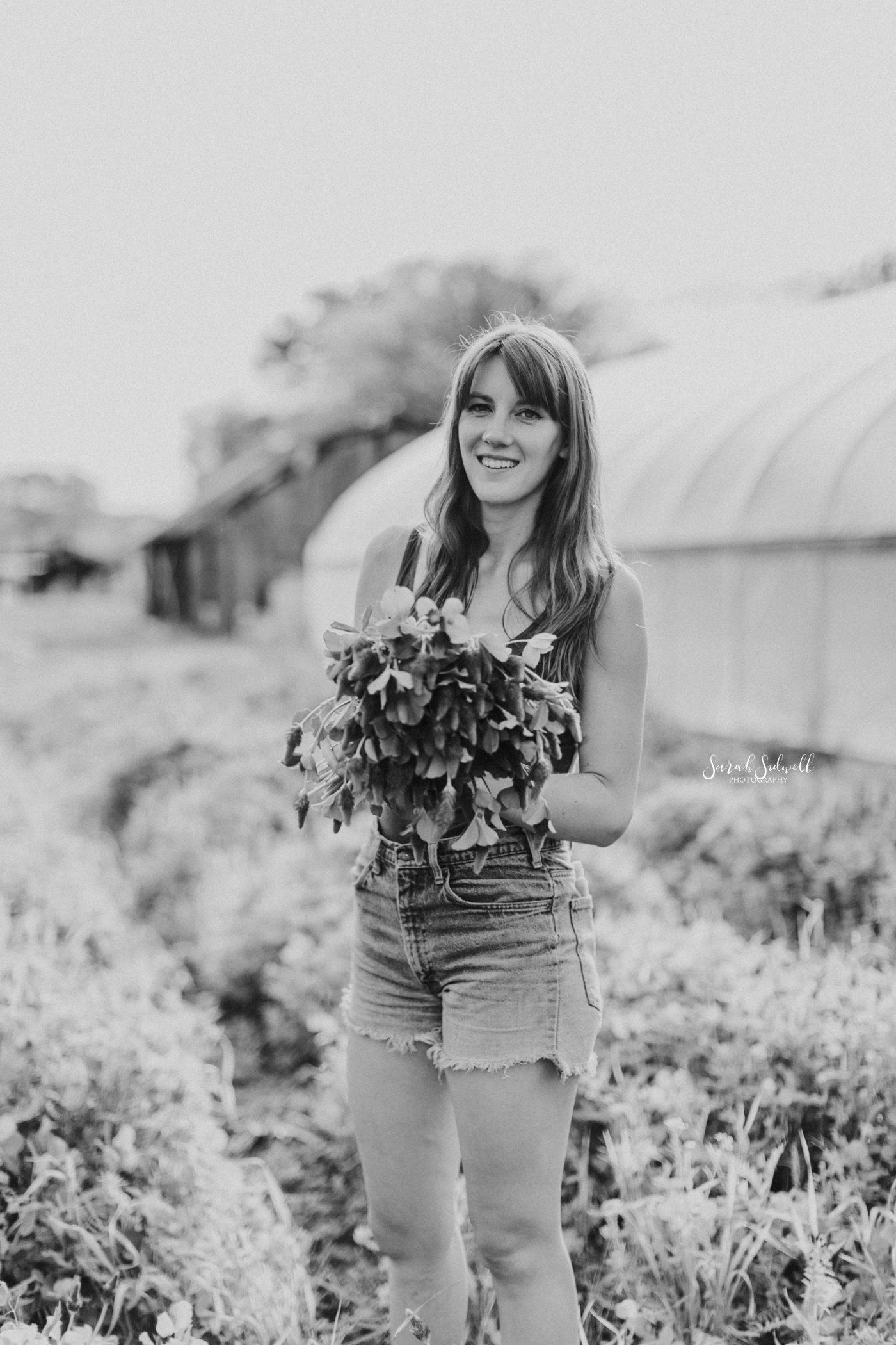 A woman holds a bouquet. 