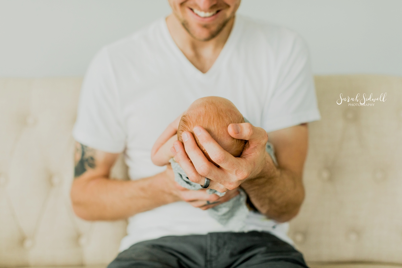 A father holds his new baby in his hands. 