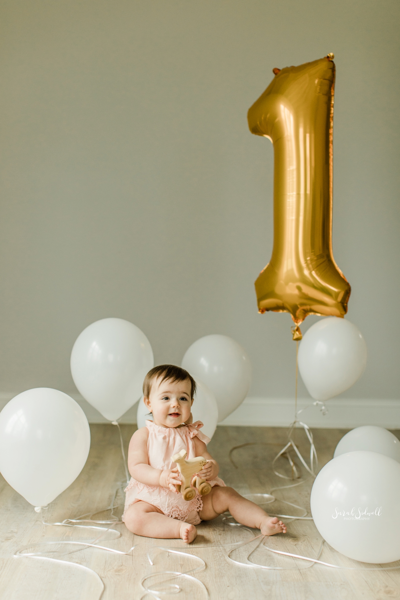 A baby plays with a number 1 balloon | Nashville Baby Photographer 