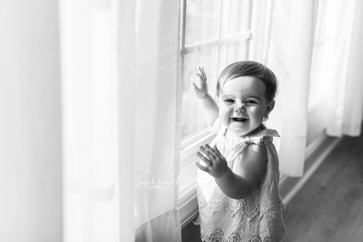 A baby girl touches a window