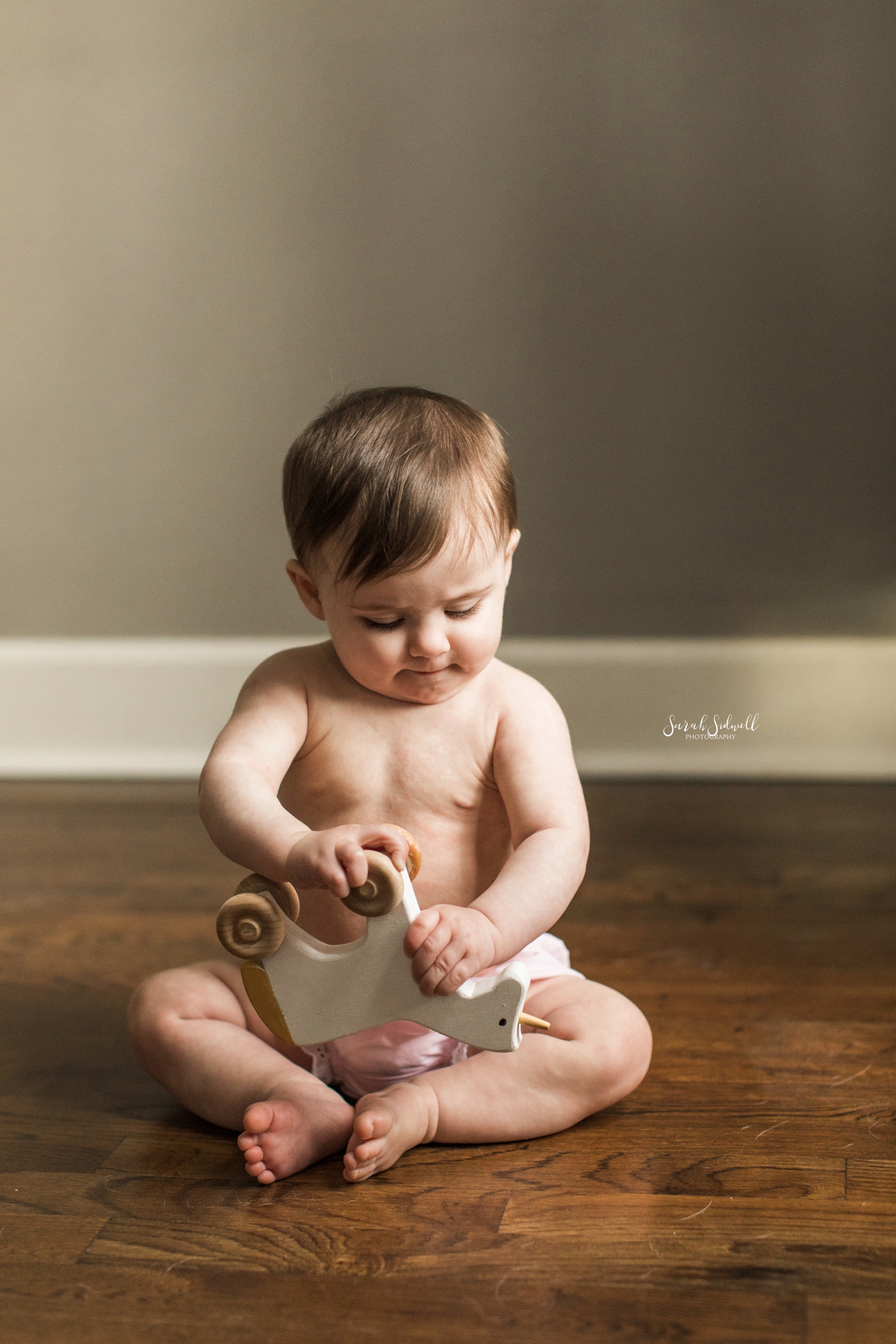 A baby sits up while playing. 