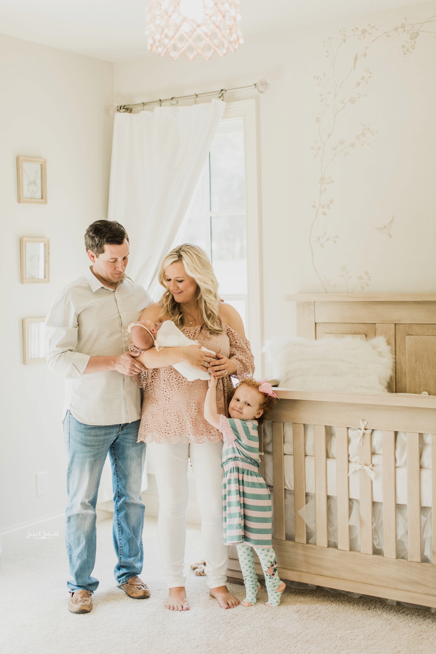 A family is standing in their baby's nursery | Home Newborn Session