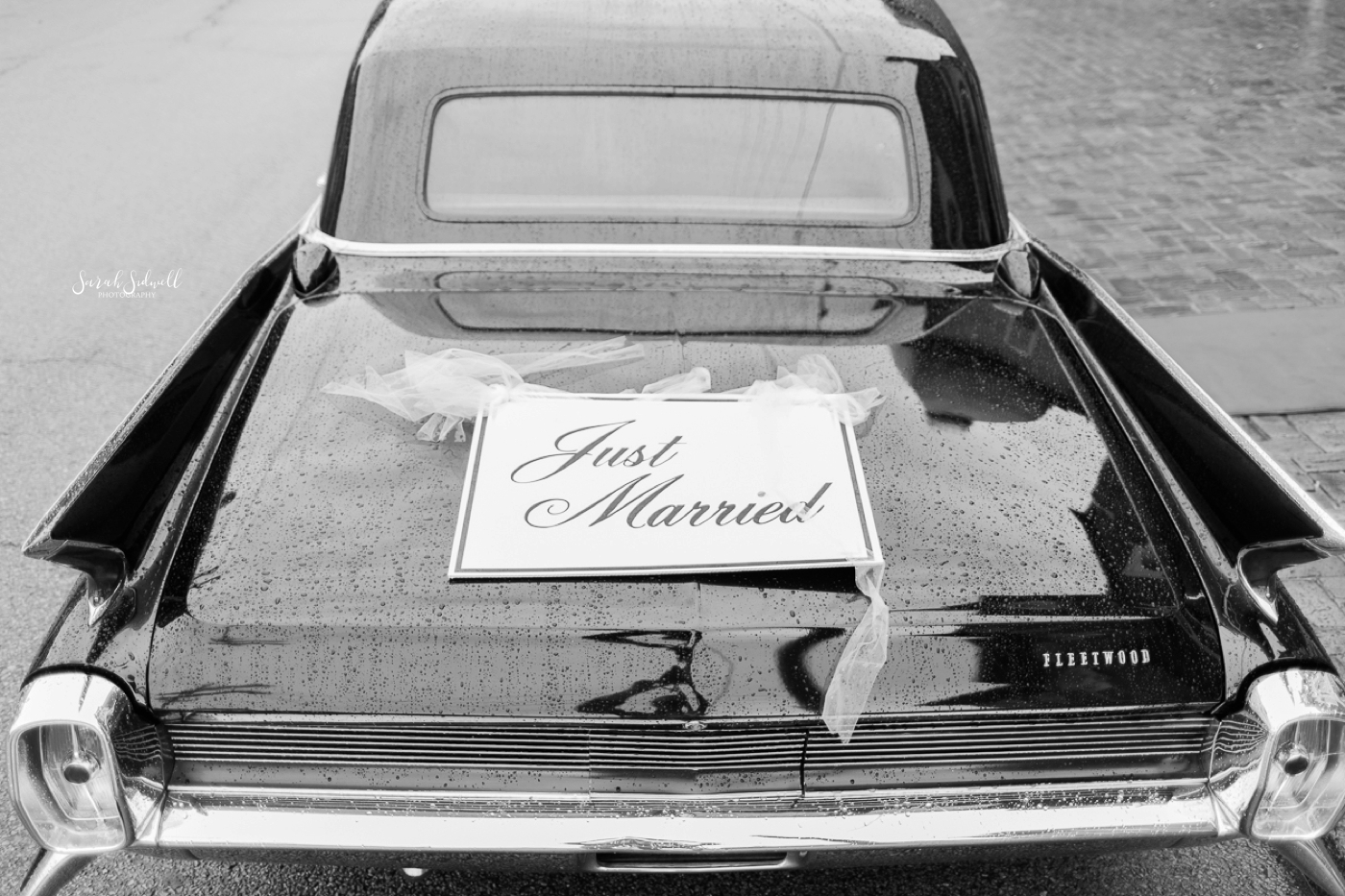 A car has a "just married" sign on the back of it. 