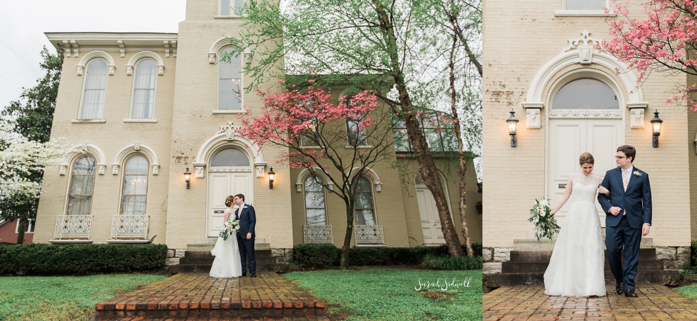A bride and groom stand in front of the East Ivy Mansion. 