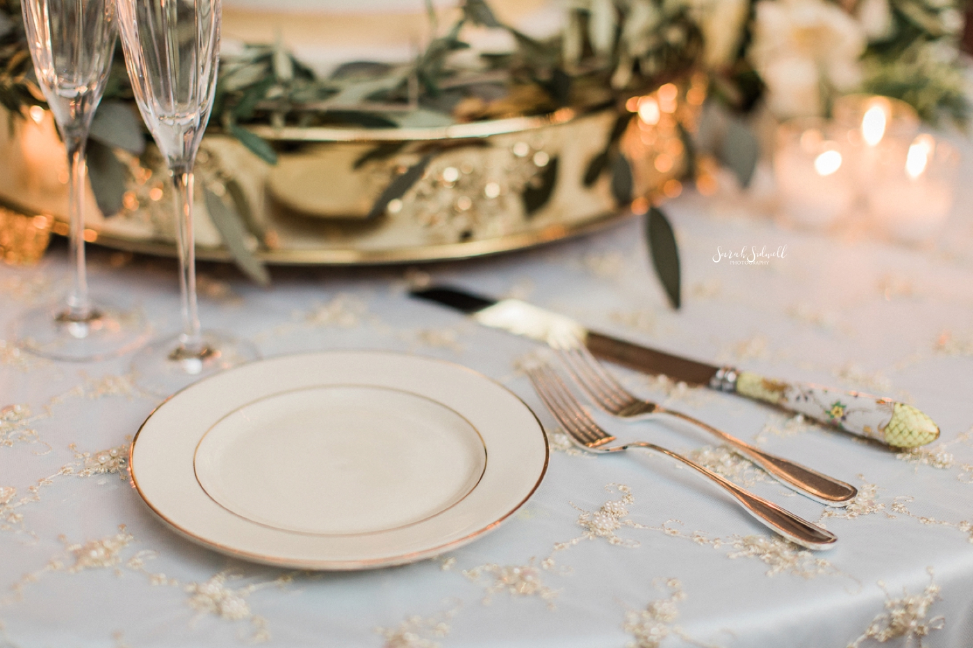 Ivory plates with golden trim are used for a wedding reception. 