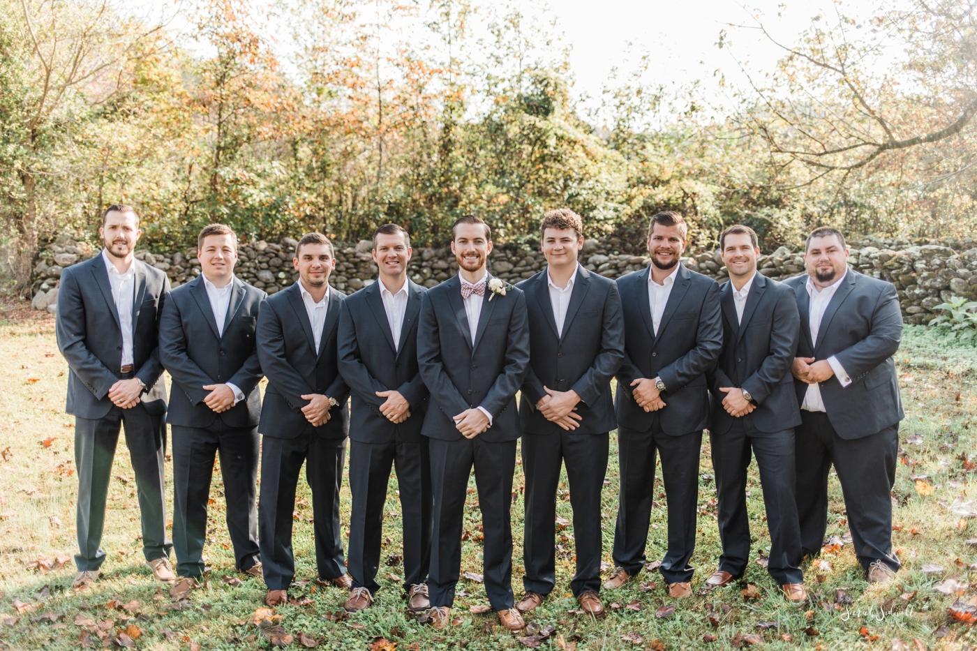 A groom and groomsmen stand in a line. 