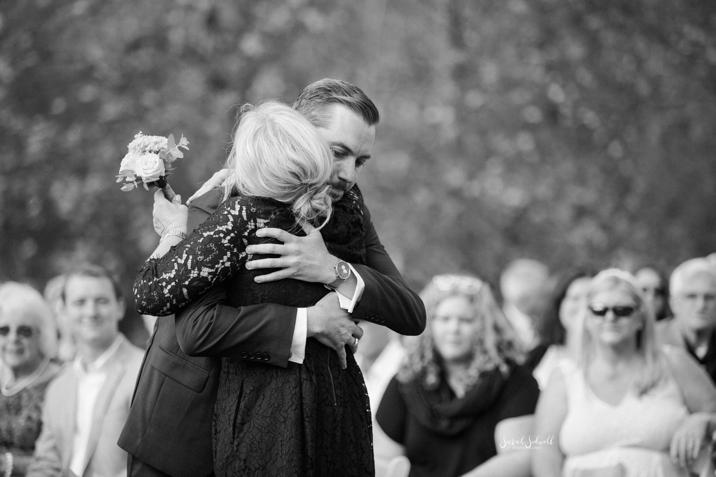A groom hugs his mom before his wedding. 