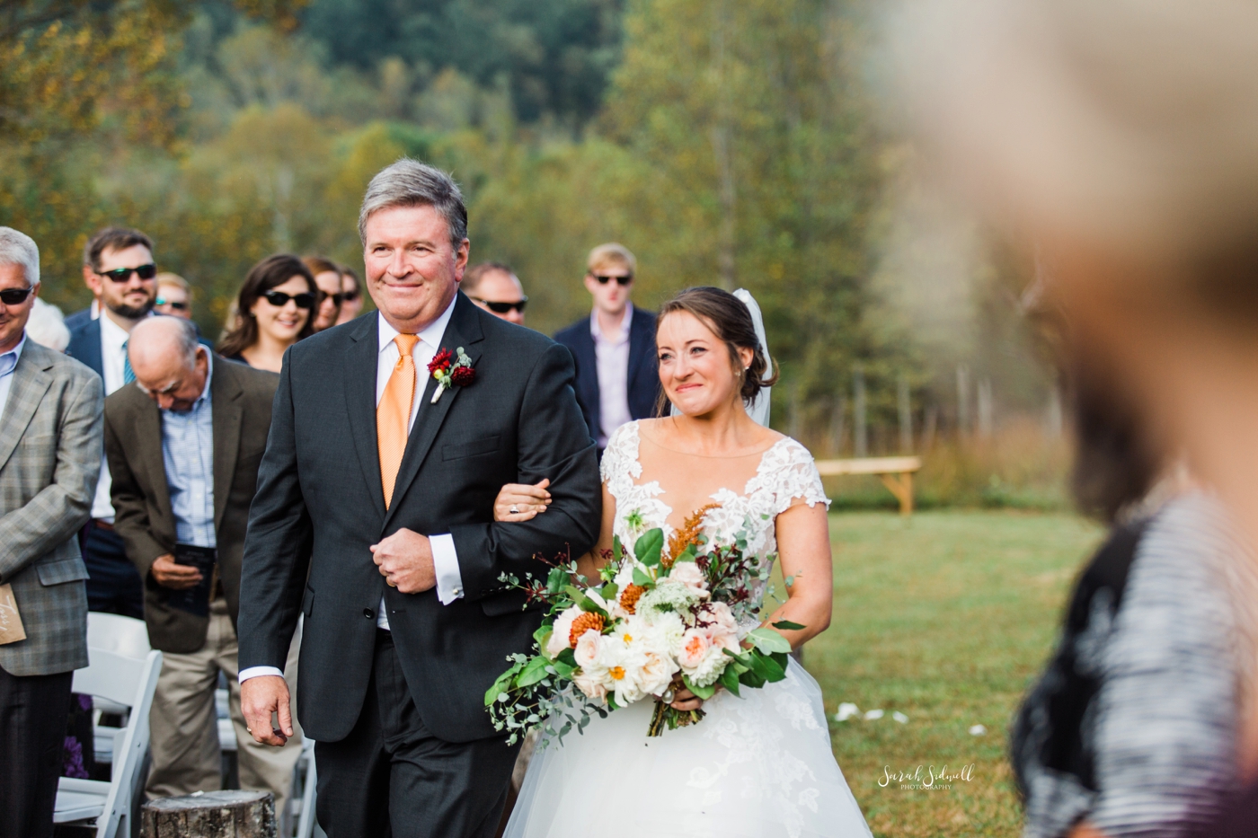 A father walks his daughter down the aisle for her wedding. 
