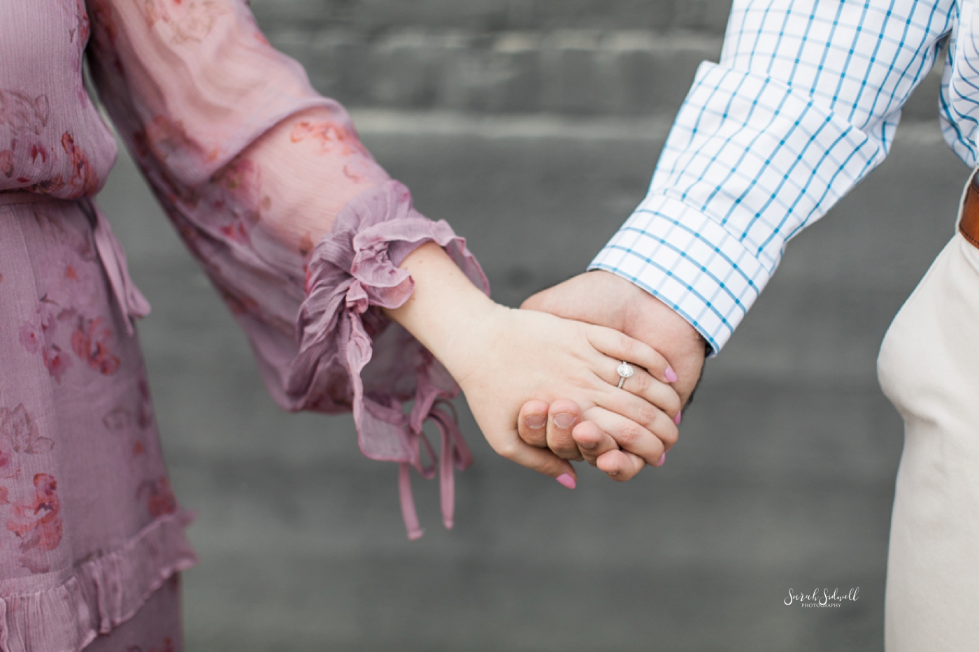 A couple hold hands during their Engagement Photographs. 