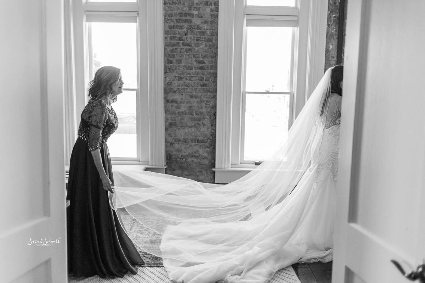 A bride's long veil is straightened out. 