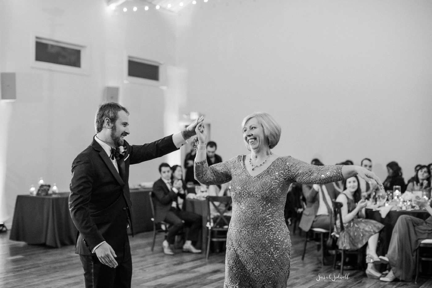 A man dances with his mother as his wedding. 