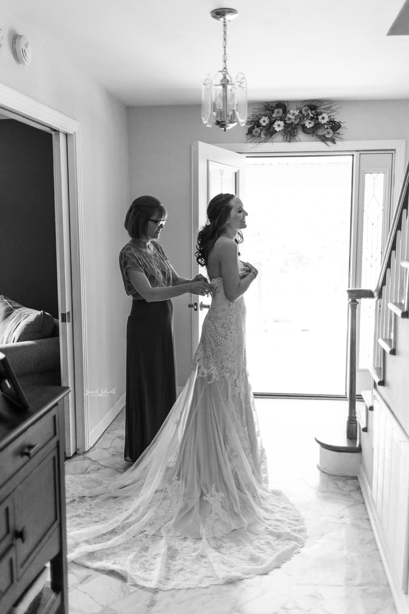 A bride gets into her dress for her wedding day. 