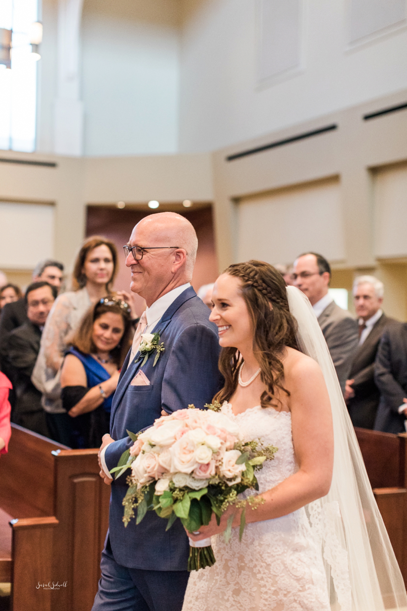 A man walks his daughter down the aisle for her wedding. 