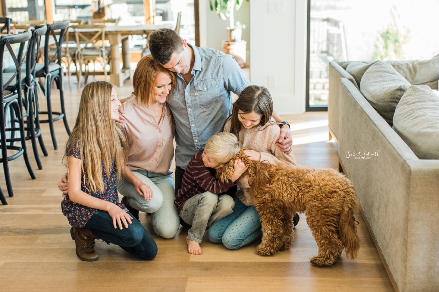 A Nashville family photographer captures a family petting their dog. 