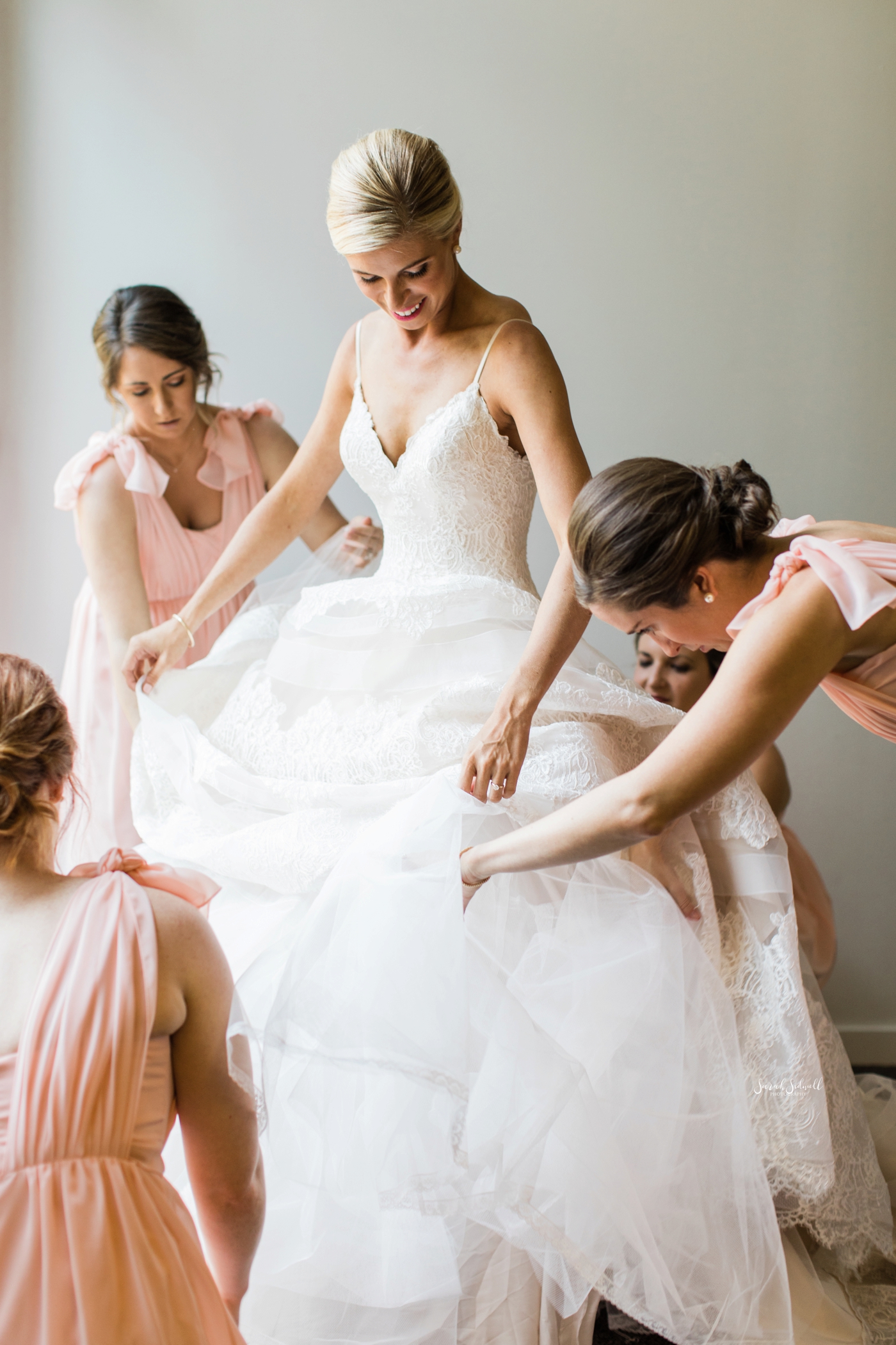 A bride gets into her wedding dress before her ceremony. 