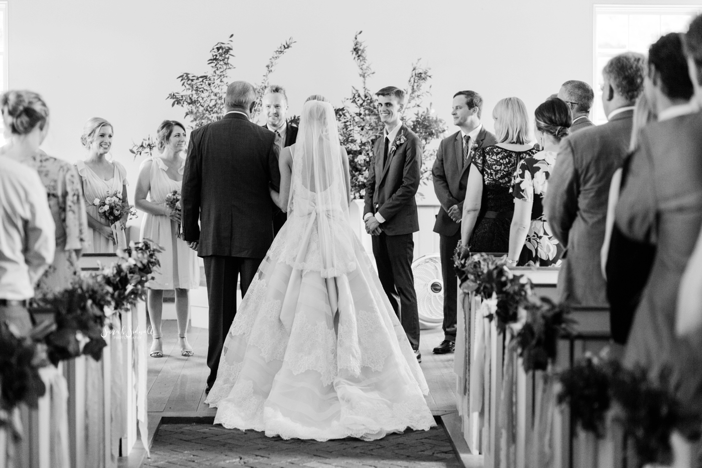 A man walks his daughter down the aisle for her wedding. 