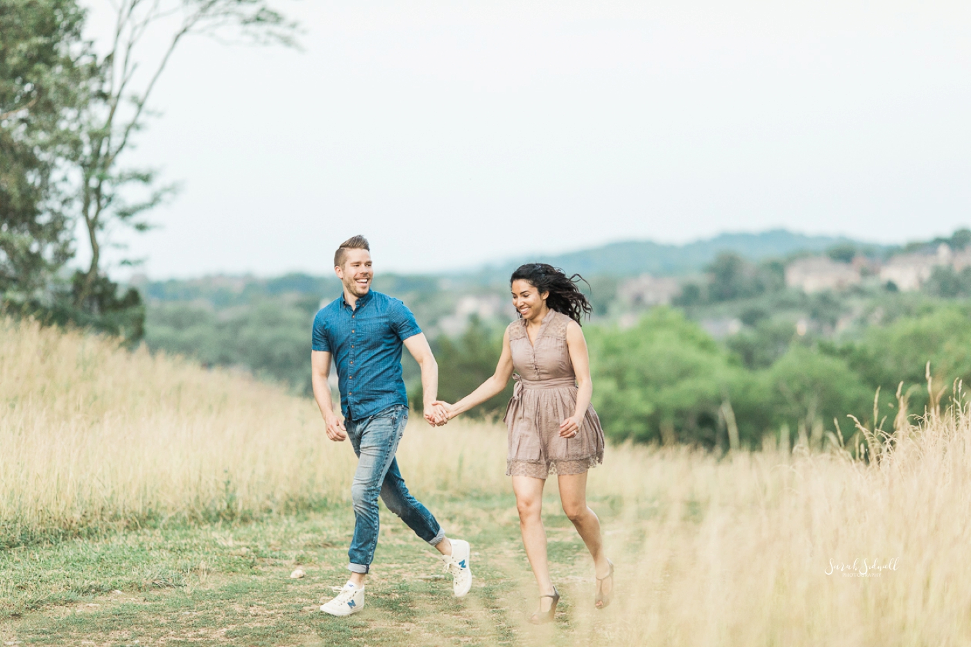 A married couple take a walk in a beautiful field together. 