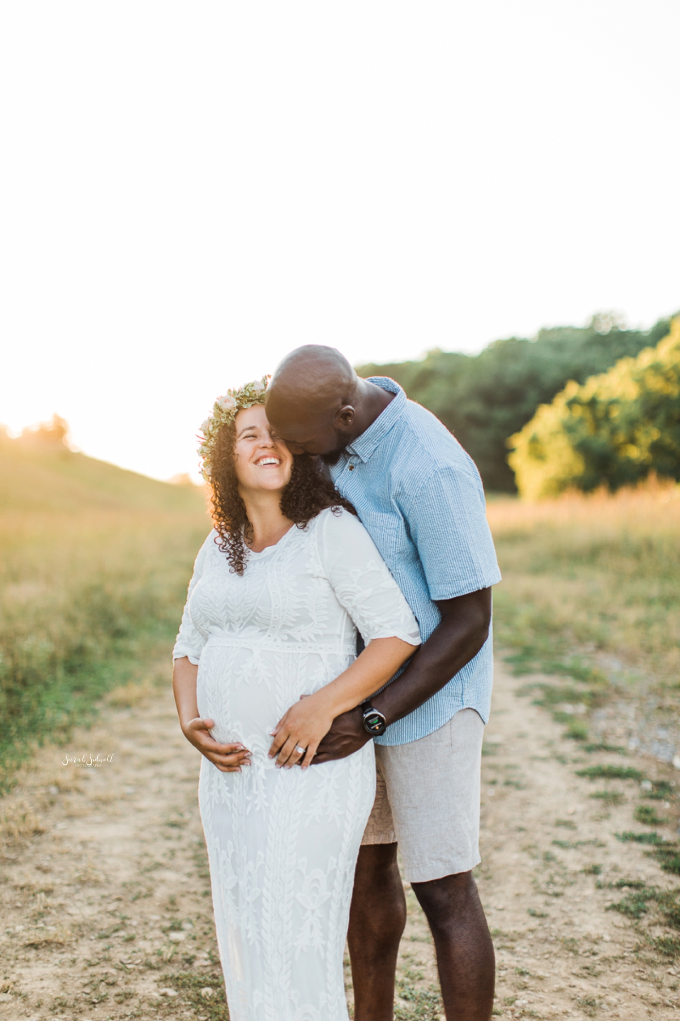 A man hugs his pregnant wife during a family maternity session. 