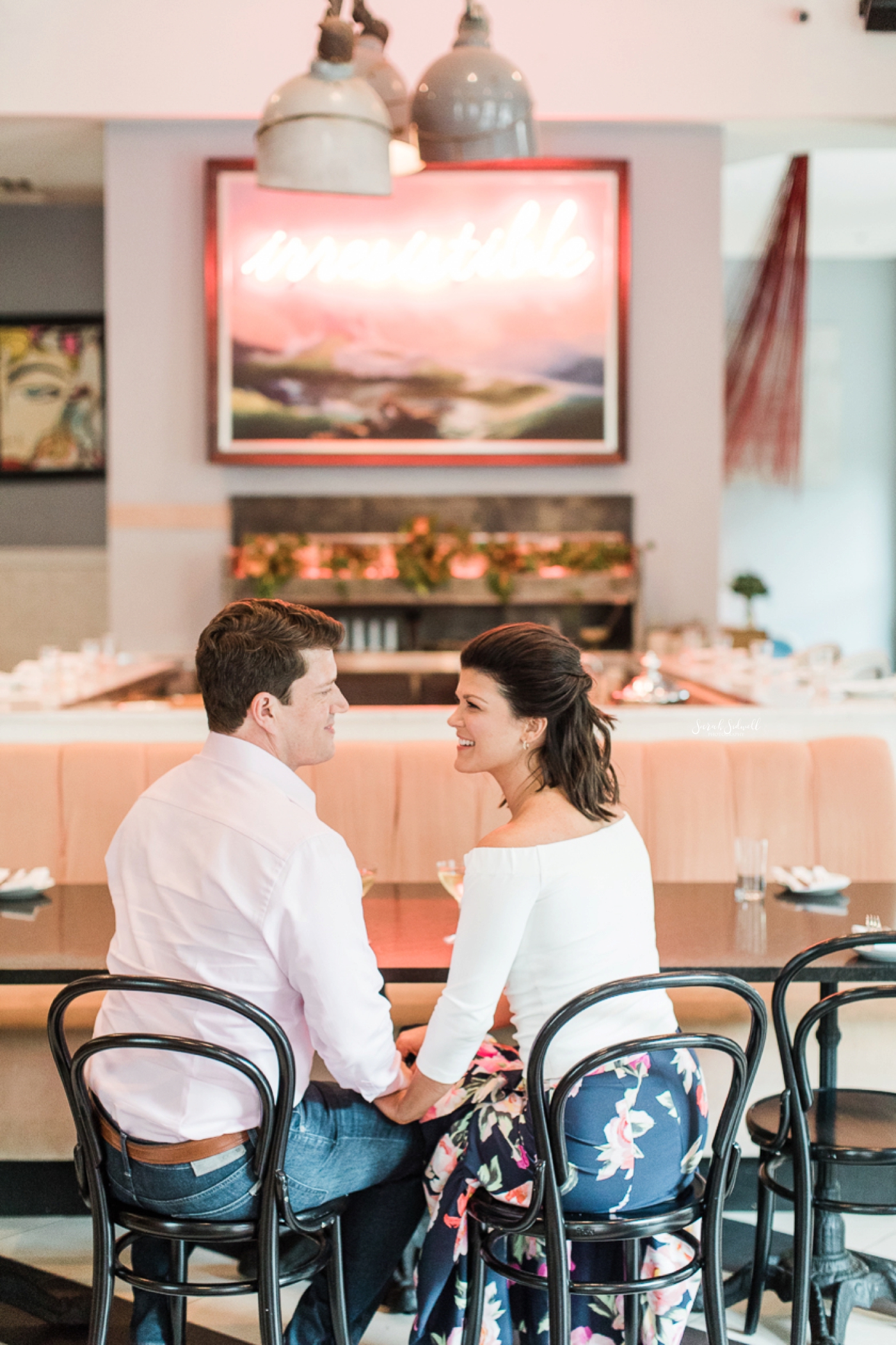 A couple sit in a diner during their engagement pictures. 