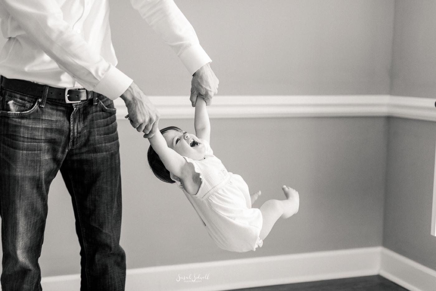 A dad swings his baby girl around. 