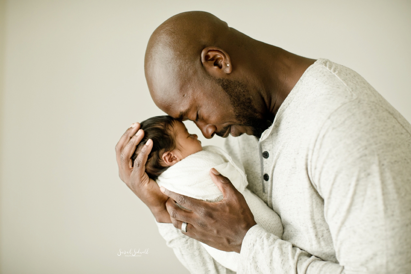 A dad snuggles his baby during her Nashville newborn pictures. 
