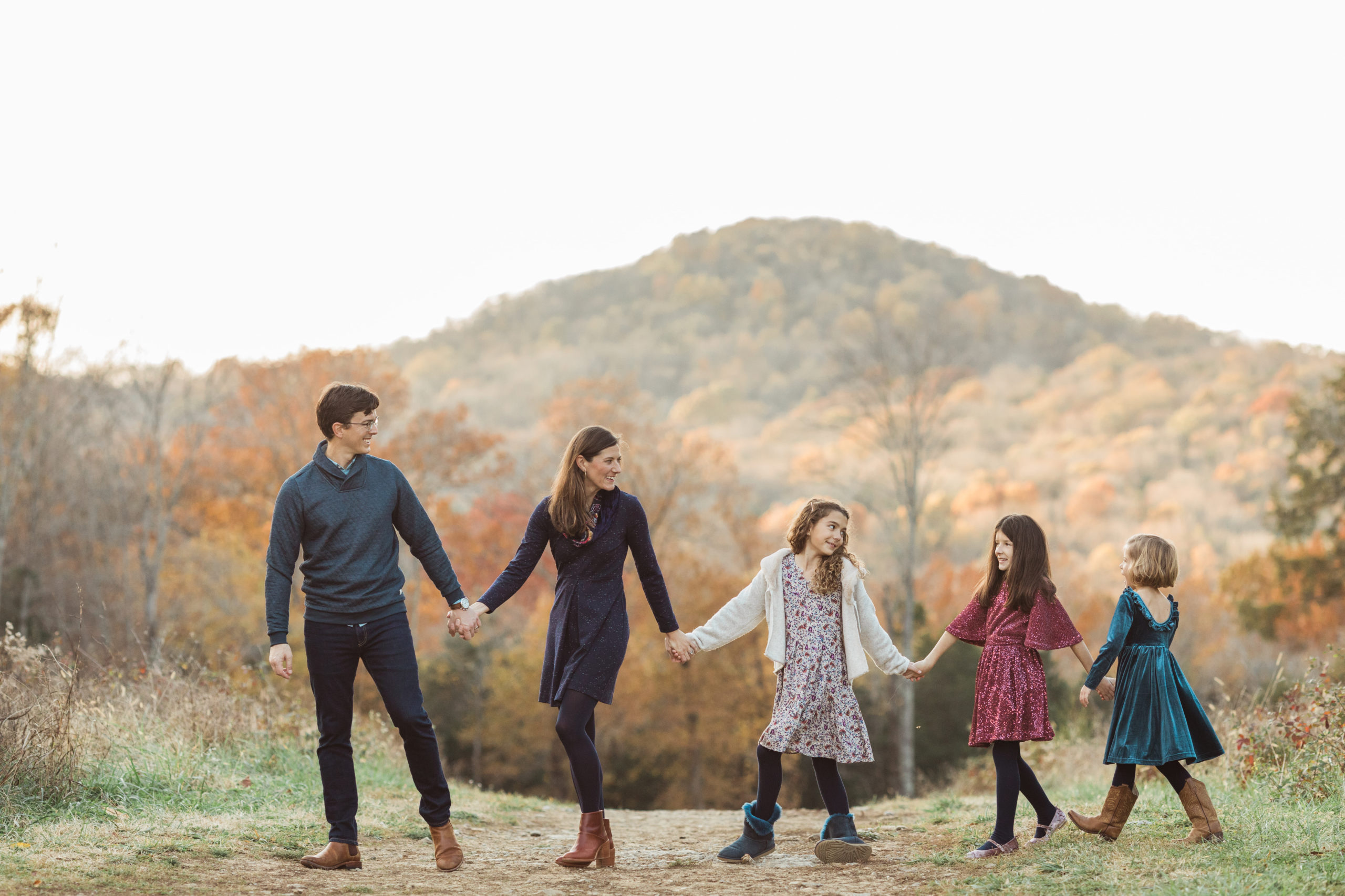 Photo of family of five holding hands and walking.