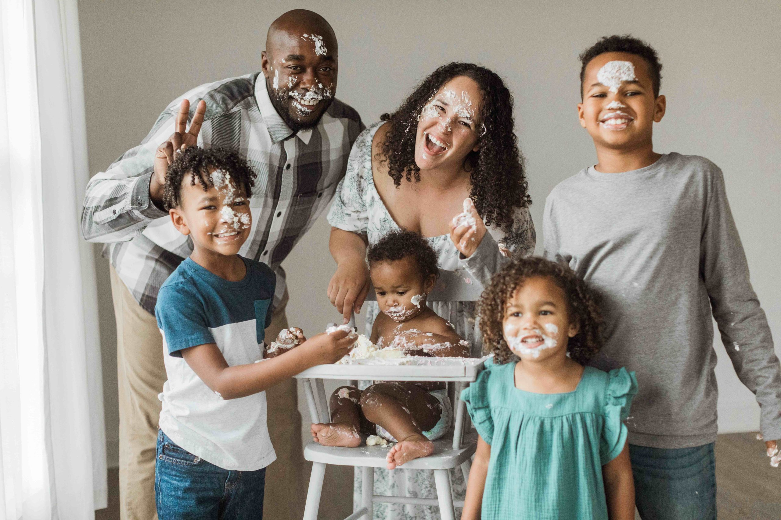 family of five smiling after putting frosting on each other. nashville family photographer