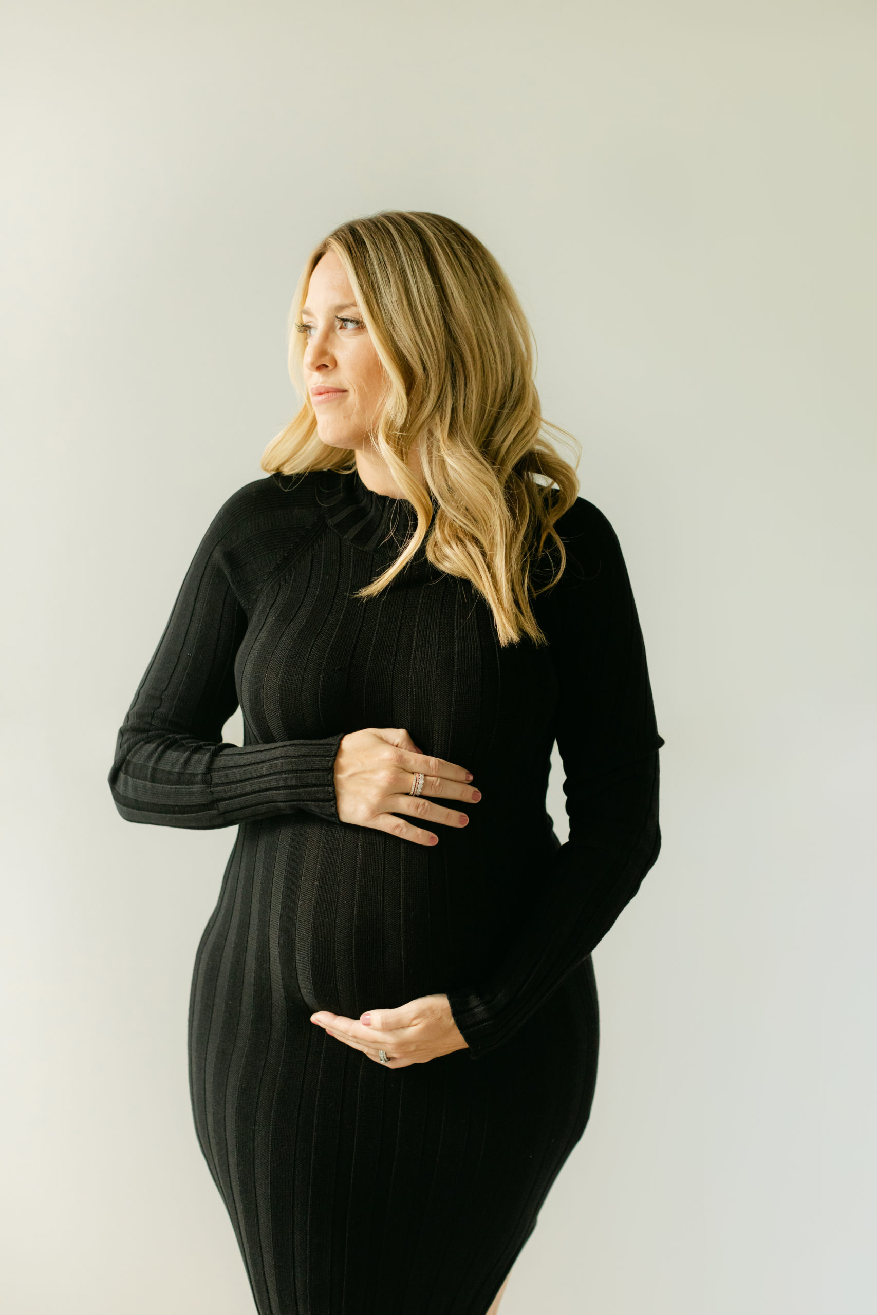 black long sleeve bodycon dress on expecting mama for her maternity photoshoot