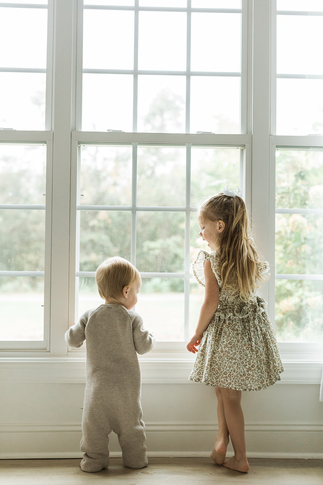 1 year old photo shoot in nashville tennessee. brother and sister looking out window