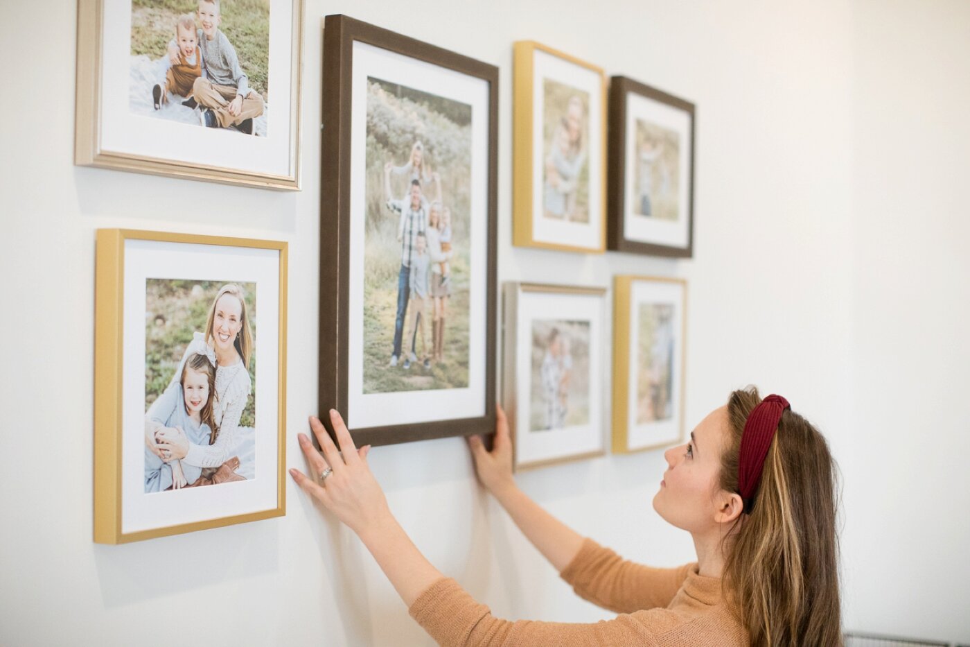 nashville family photographer hanging up framed photos on wall