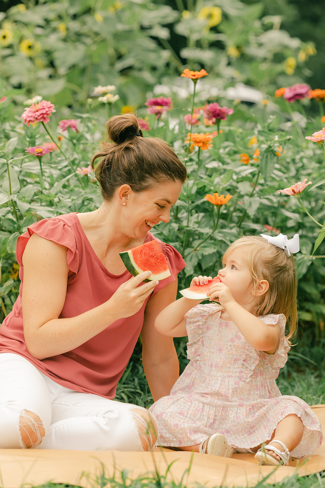 outdoor motherhood minis in garden. photographed in nashville photographer. mom and daughter eating watermelon
