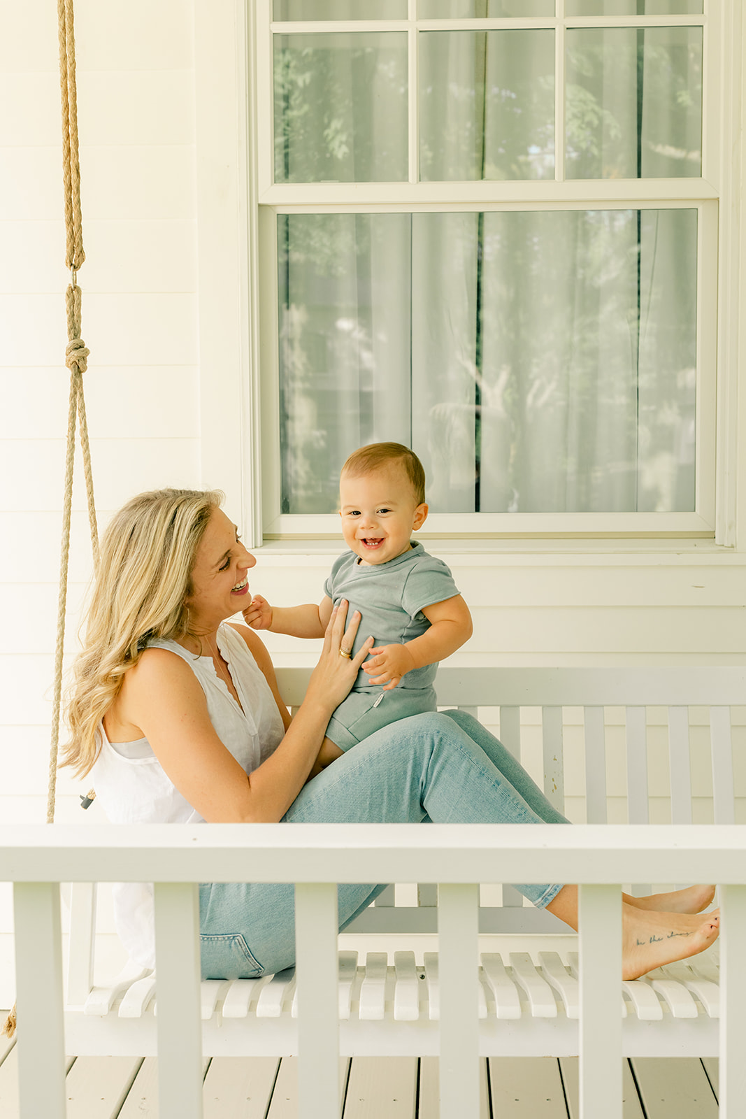 1 year milestone session for baby boy. Cozy at home session. mama and son sitting on front porch swing