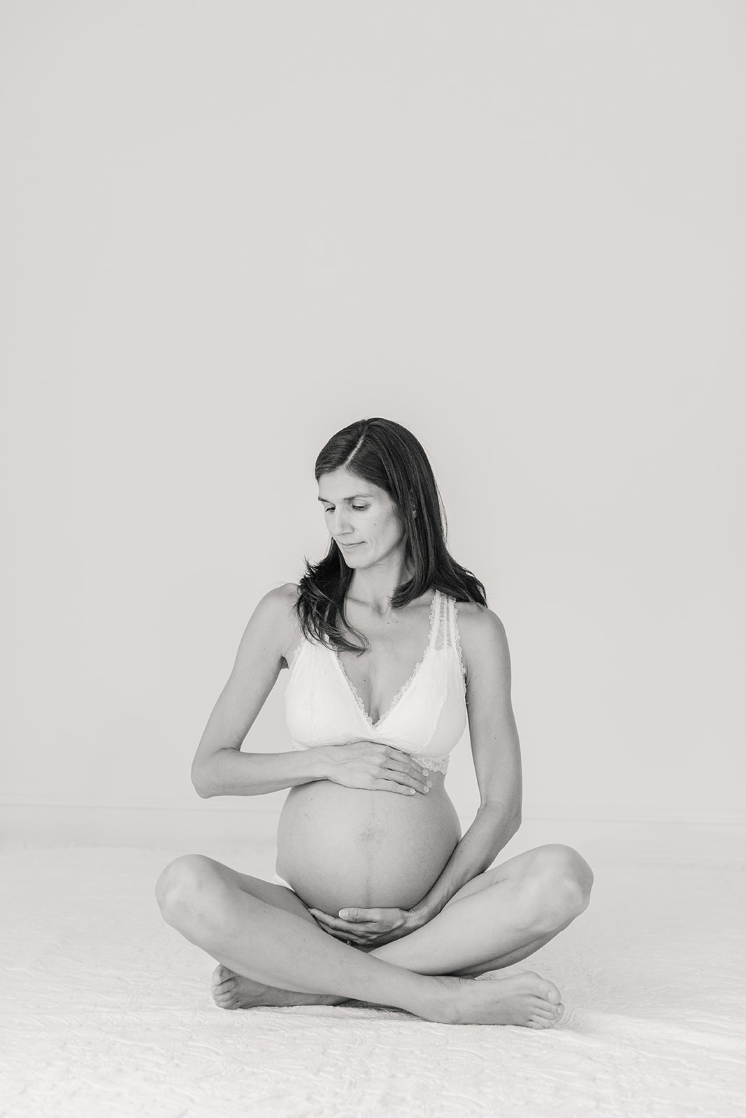 body empowerment and maternity session in nashville studio. mama sitting criss cross holding her belly