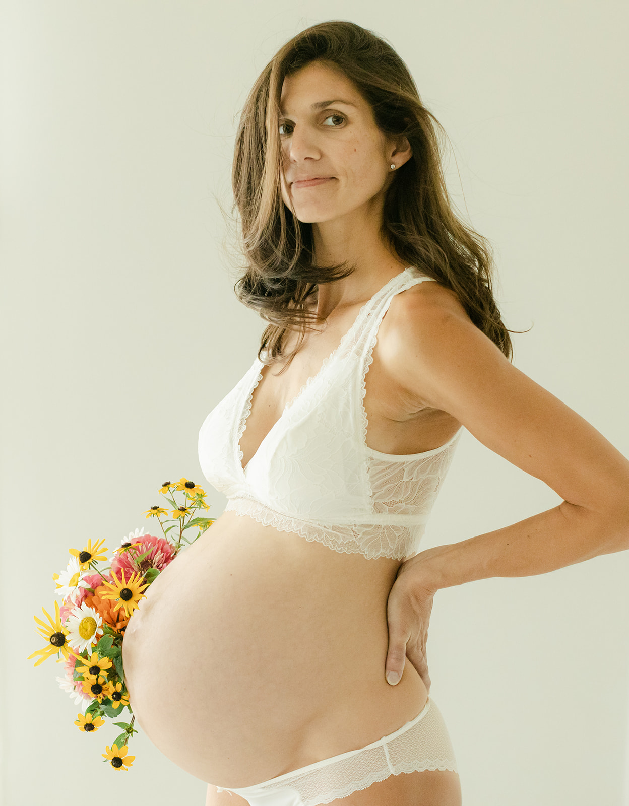 body empowerment and maternity session in nashville studio. mama posing with floral bouquet