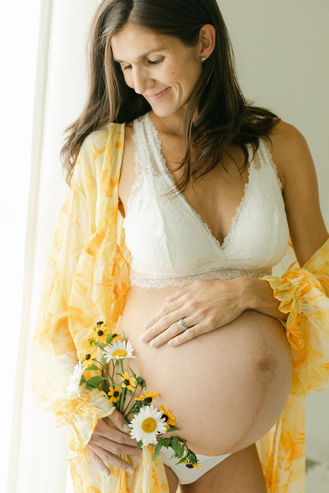 body empowerment and maternity session in nashville studio. mama holding wild flower bouquet