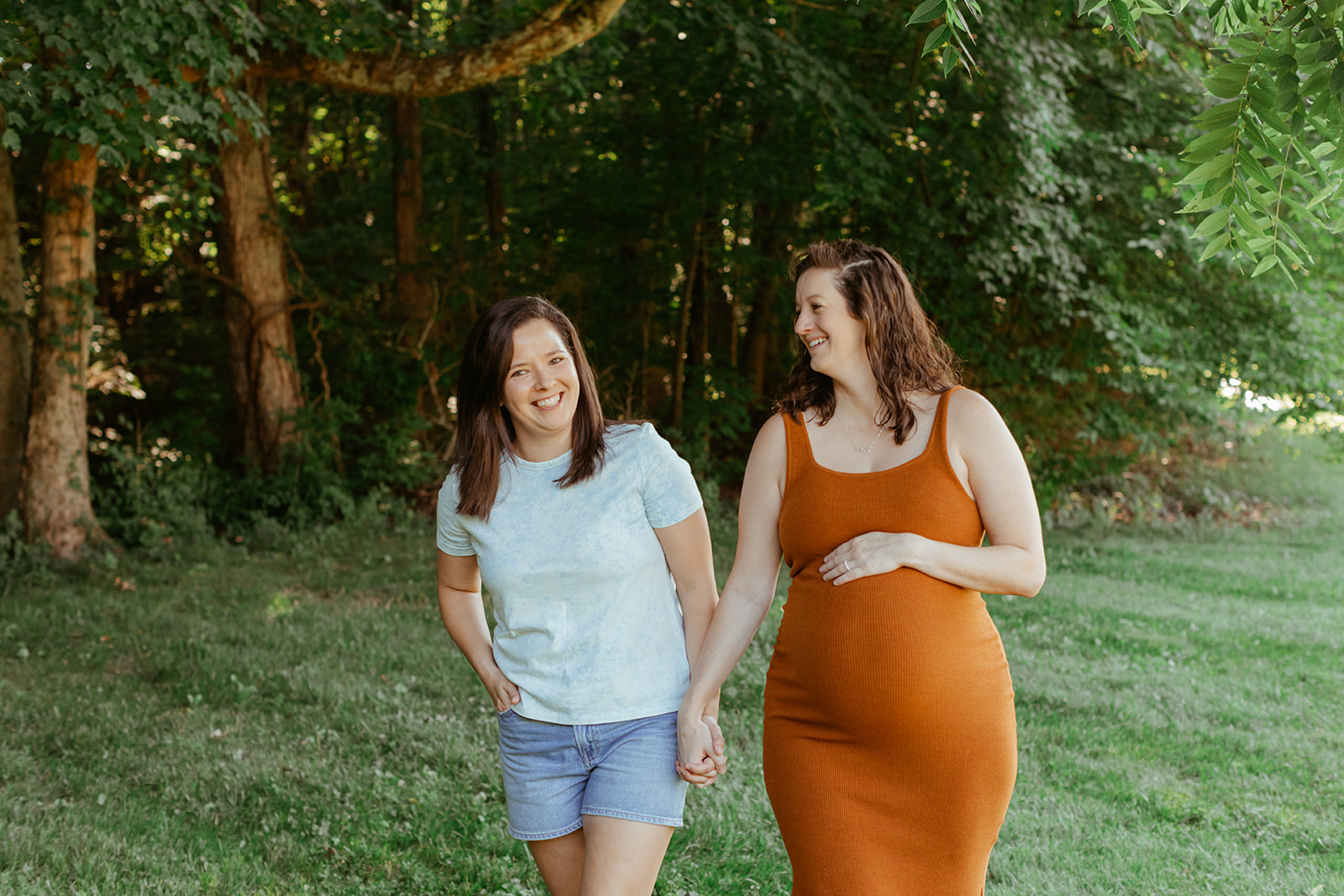 LGBTQ moms holding hands walking. Maternity session & backyard summer family session in Nashville, TN