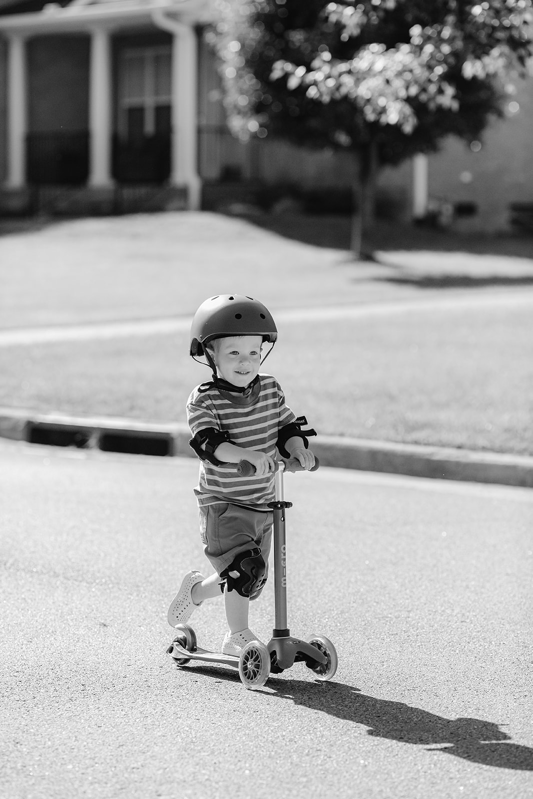 Little boy on scooter and helmet. Backyard summer family session in Nashville, TN