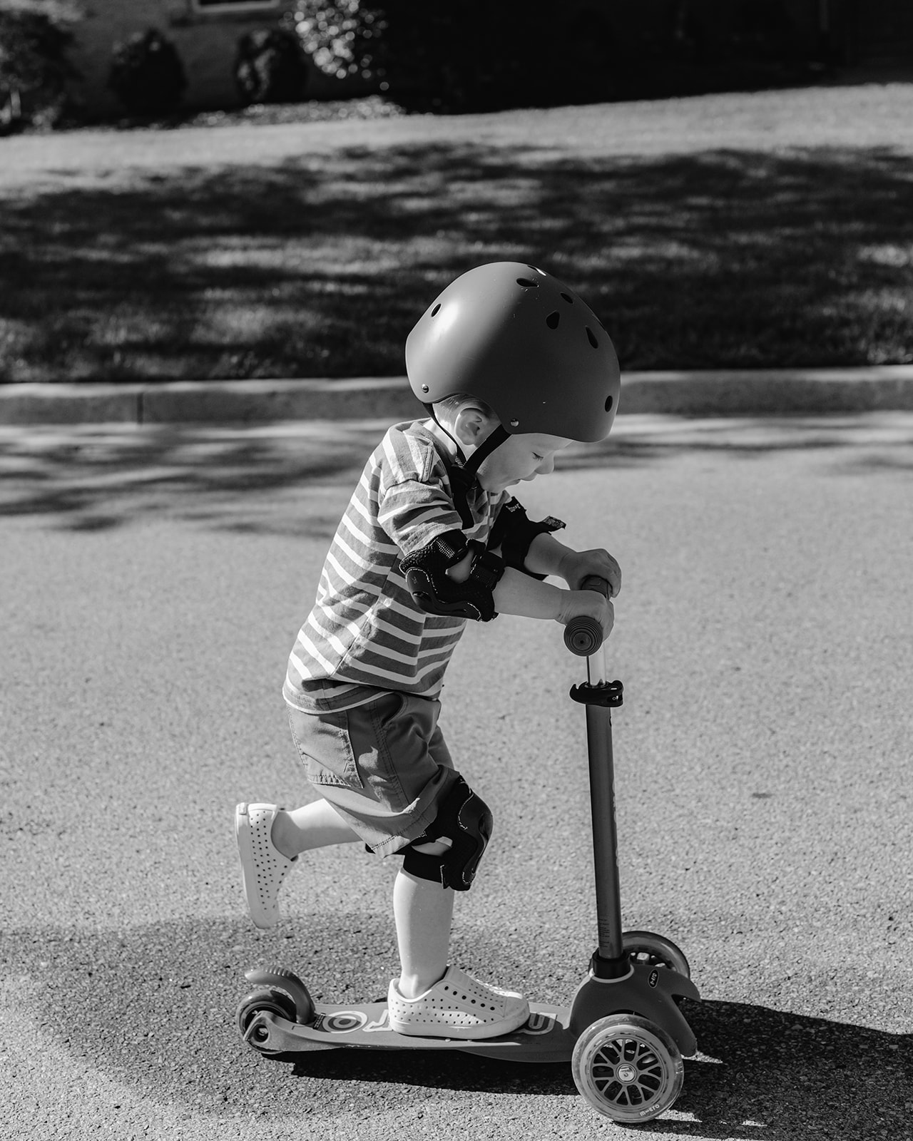 Little boy on scooter and helmet. Backyard summer family session in Nashville, TN