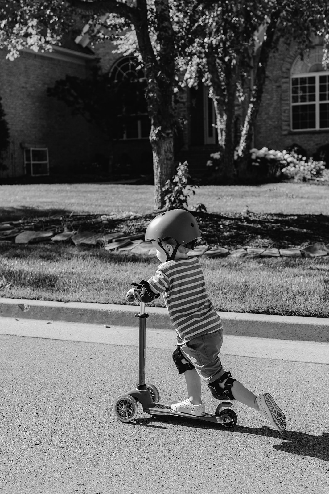 Little boy on scooter and helmet. Backyard summer family session in Nashville, TN