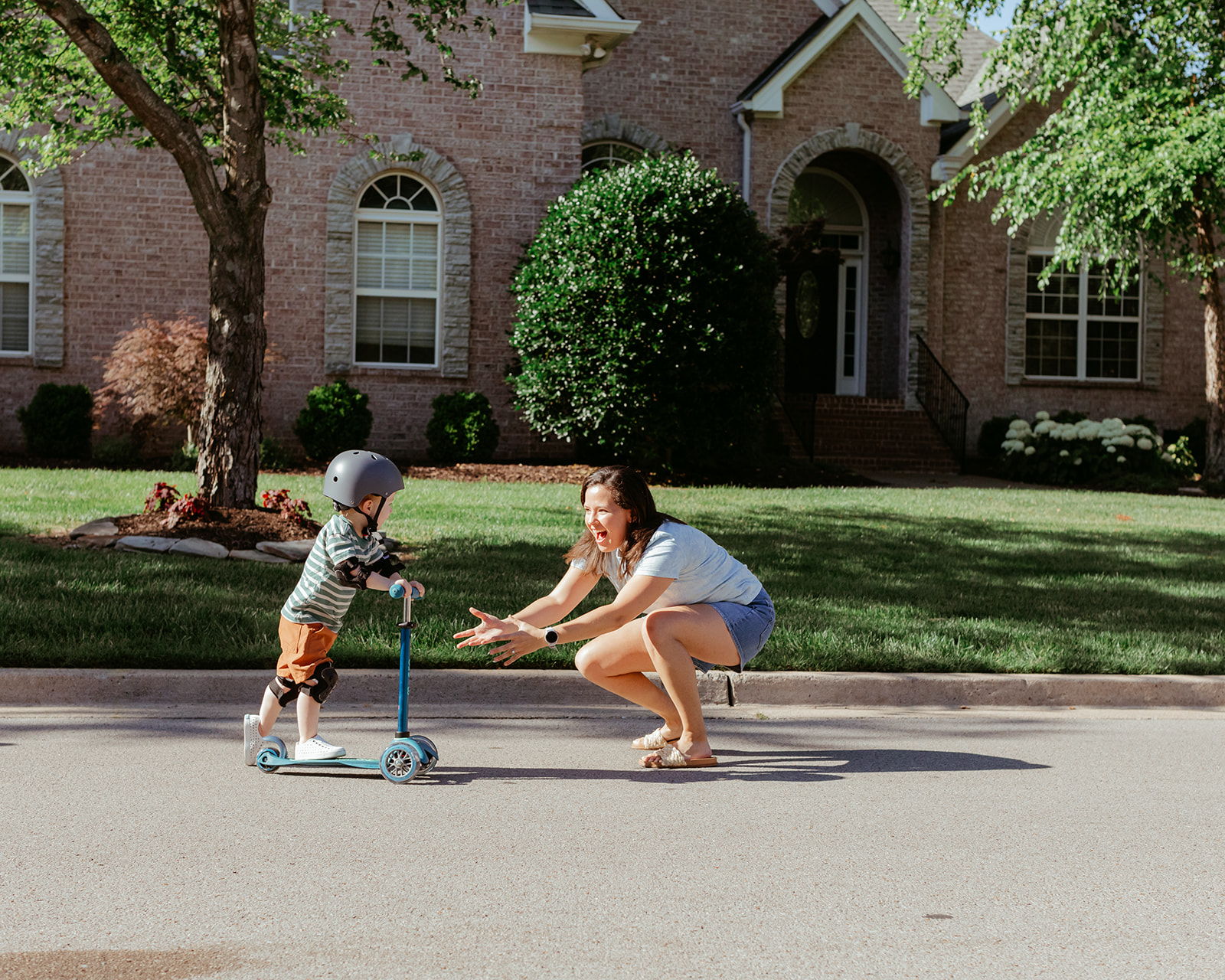 Mama with son. Little boy on scooter wearing helmet. Backyard summer family session in Nashville, TN